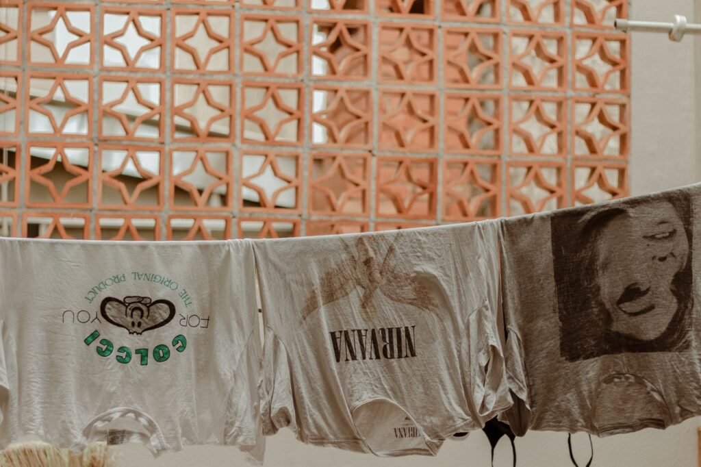 Retro t-shirts, including a Nirvana print, drying outdoors on a clothesline.